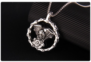 Detailed close-up of a silver punk skull pendant featuring a realistic motorcycle chain border