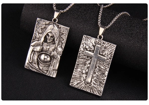 Gros plan du collier en acier inoxydable vintage avec croix et pendentif sorcière