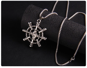 Macro detail of vintage anchor helm pendant with textured box chain on dark display