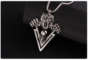 Macro detail of gothic tiger skull pendant with dark silver finish on leather surface