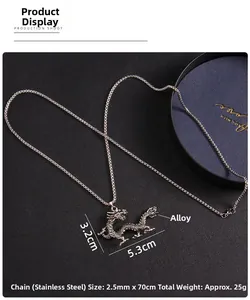 Detail of silver dragon pendant with stainless steel chain on a dark textured surface