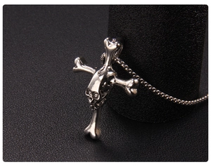 Collana con ciondolo a teschio e ossa incrociate finitura argento antico su base nera