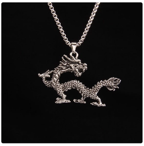 Detailed view of an antique silver dragon pendant necklace with intricate carvings