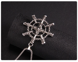 Macro shot of silver helm pendant with star detail on black leather background