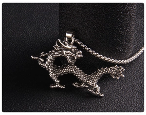 Close-up of retro dragon pendant with detailed scales on black leather background