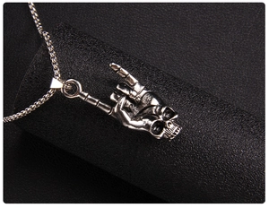 Macro detail of punk rock skull love gesture necklace in vintage stainless steel finish