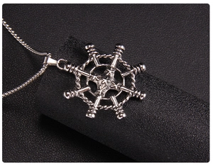 Detail of silver nautical rudder pendant with rope texture on black leather background