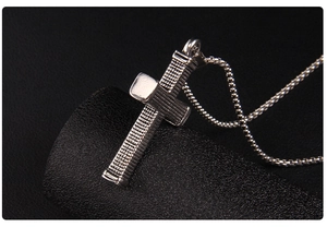 Detailed macro shot of vintage silver cross pendant with unique textured grid pattern