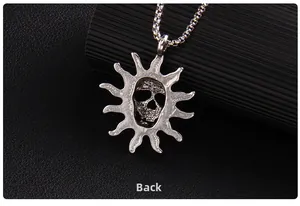 Macro back view of vintage silver punk skull pendant with sunburst detailing on black leather