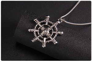 Detailed close-up of a silver nautical anchor pendant with star relief on snake chain