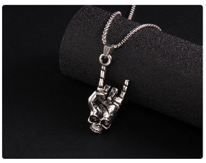 Close-up of a punk rock skull hand pendant in antique silver finish on black leather