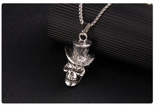Macro detail of gothic skull pendant with top hat on vintage box chain necklace