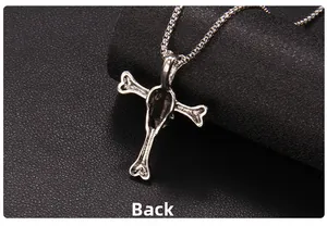 Dettaglio macro del retro di una collana gotica a croce con teschio in acciaio inox