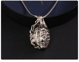 Close-up of vintage silver necklace pendant featuring a dual Buddha and Demon design