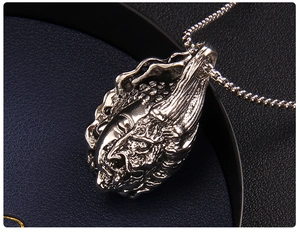 Detailed close-up of intricate double-sided Buddha and demon relief on vintage pendant