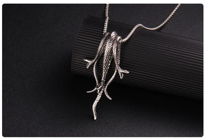 Macro shot of silver retro snake-shaped pendant with detailed scale texture and chain