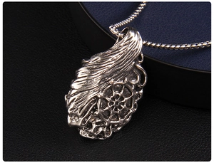 Macro detail of a vintage nautical rudder pendant with an oxidized silver finish