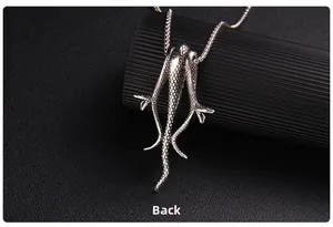Detailed close-up of retro silver claw pendant with intricate scales on a box chain