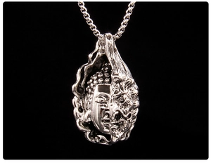 Macro shot of silver retro buddha pendant with organic details on a black box chain