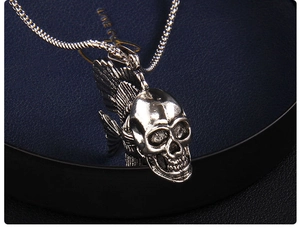 Gros plan d'un pendentif poisson crâne punk en argent vieilli avec chaîne en métal