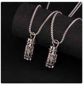 Macro detail of vintage silver TNT pendant necklaces with 520 engraving and box chains