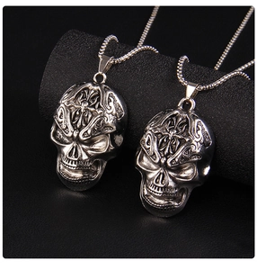Detailed close-up of retro silver skull pendants with gothic engravings and metal bead chain