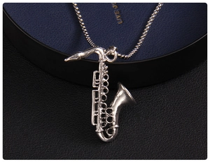 Macro shot of vintage silver saxophone pendant with detailed musical textures on ball chain