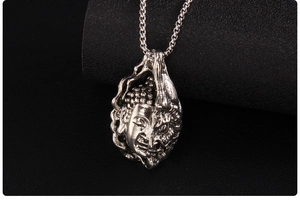 Macro shot of dual-faced Buddha and Demon pendant with vintage oxidized metal texture