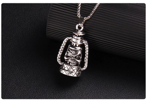 Macro shot of vintage silver skull kerosene lamp pendant on square pearl chain