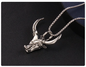 Gros plan d'un pendentif tête de taureau argenté avec texture rétro sur cuir noir