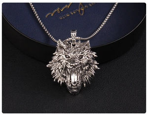 Macro close-up of a vintage steel wolf head pendant featuring detailed fur and roar texture
