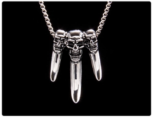 Detailed view of silver stainless steel triple skull pendant with gothic punk spikes