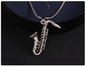Macro detail of silver saxophone pendant necklace with vintage texture on leather background