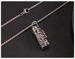 Detail of silver Gatling gun pendant with intricate mechanical industrial metalwork