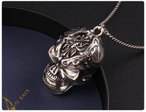 Detailed view of silver gothic skull pendant with cross relief on round pearl chain