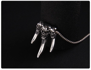 Macro shot of three stainless steel skulls and talons on a gothic punk pendant necklace