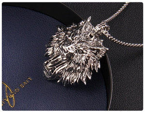Macro view of a silver wolf head pendant with detailed carving and metallic texture