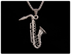 Close-up of vintage silver saxophone pendant with detailed musical instrument texture