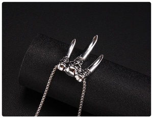 Close-up of punk style stainless steel trident claw necklace with skull engravings