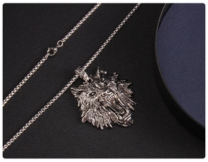 Macro view of a detailed roaring wolf head pendant on a silver box chain necklace