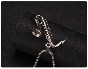 Macro shot of silver stainless steel saxophone pendant with realistic key details