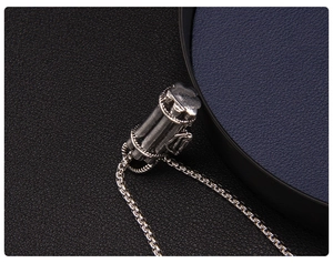 Macro shot of industrial silver cylinder pendant with intricate textured details