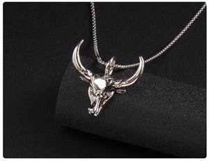 Vue macro du pendentif tête de taureau argenté avec texture vintage sur support noir