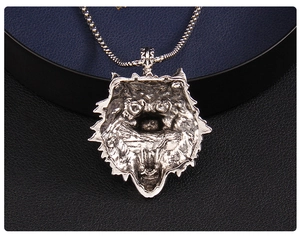 Macro shot of silver wolf head pendant showing hollow structure and vintage texture