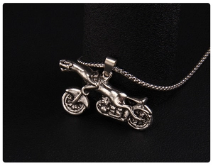 Detail of vintage leopard motorcycle pendant with antique silver finish and woven chain