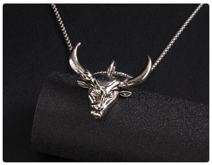 Gros plan d'un collier pendentif tête de taureau argenté avec des gravures détaillées