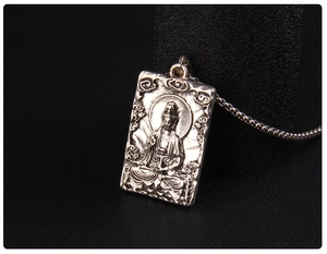 Dettaglio macro del rilievo vintage di Guanyin Bodhisattva sul ciondolo in acciaio