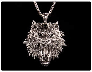 Close-up of a roaring wolf head pendant in vintage silver steel with a thick chain