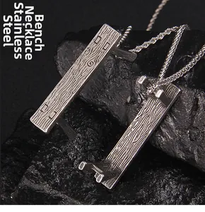 Macro detail of stainless steel necklace showing wood grain texture on bench pendant