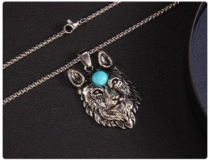 Macro detail of gothic wolf head pendant featuring engraved fur and a blue gemstone